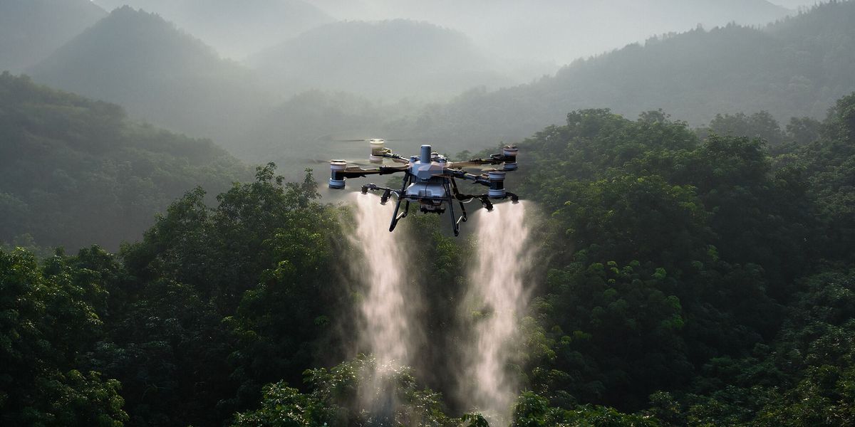 Drone agrícola DJI Agras pulverizando uma plantação sobre a mata